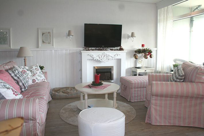 Wohnzimmer mit Couch, TV und Sessel